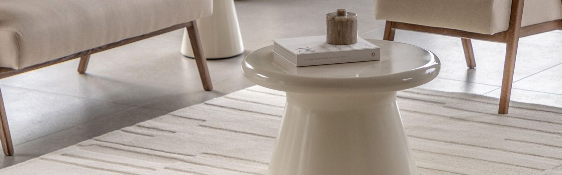 A modern, neutral-toned living area, focusing on a rectangular Tufted Tonal Rug in white or a very light cream colour.