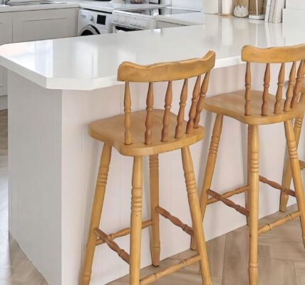 A white kitchen island or breakfast bar with a clean, white countertop. The side facing the viewer appears to be finished with white vertical panelling - possibly V-groove or tongue and groove style.