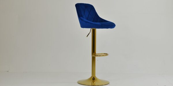 A modern blue velvet bar stool with a diamond-quilted backrest and a polished gold pedestal base.