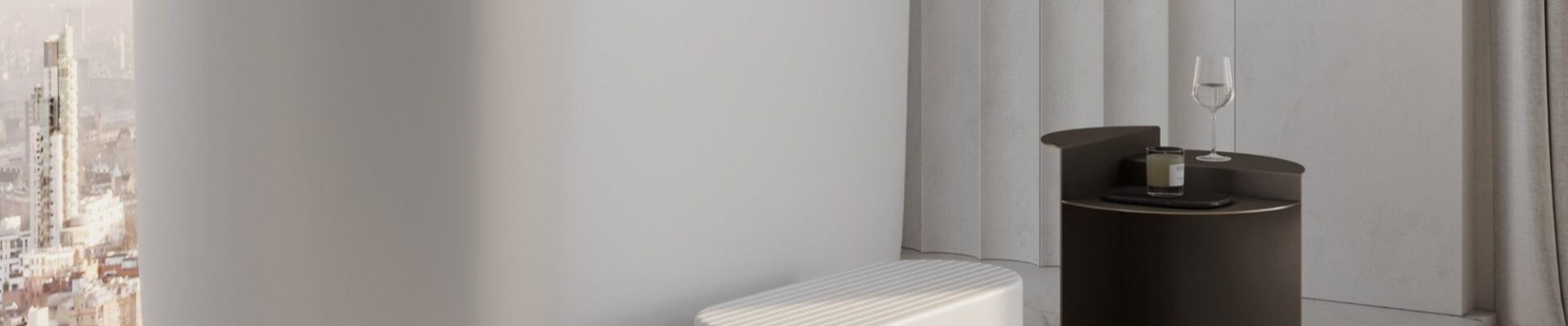 This image features a modern, luxurious bathroom with a large, freestanding white soaking tub positioned next to a window that offers a view of a city skyline at what appears to be sunrise or sunset.