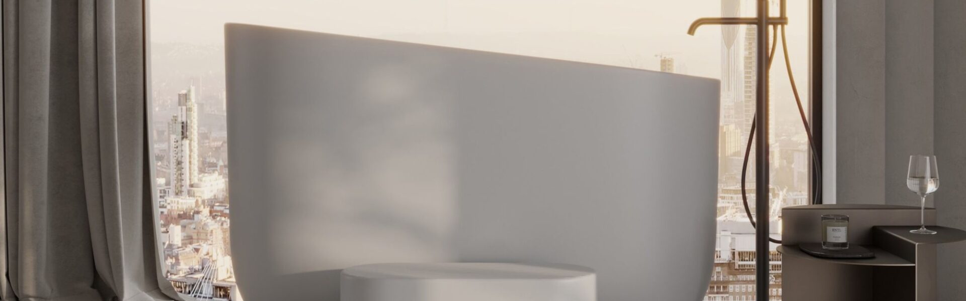 A minimalist, high-angle interior shot of a modern bathroom featuring a matte white stone Japanese soaking tub as the centrepiece. The tub has a sleek, asymmetrical rim that rises higher on one side, positioned in front of a floor-to-ceiling window overlooking a hazy city skyline at sunset.