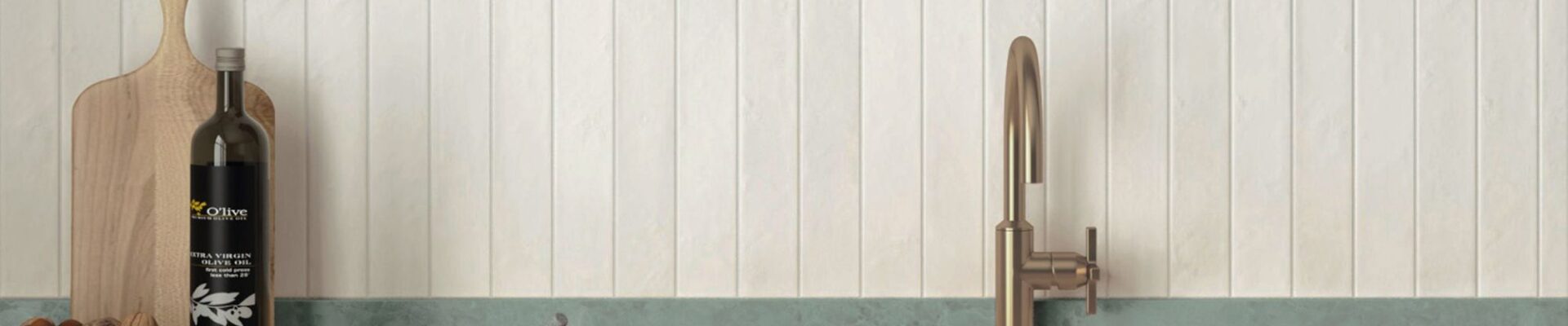 An eye-level, horizontal shot of a modern, minimalist kitchen features a vertical stack-bond backsplash made of textured, off-white rectangular tiles.