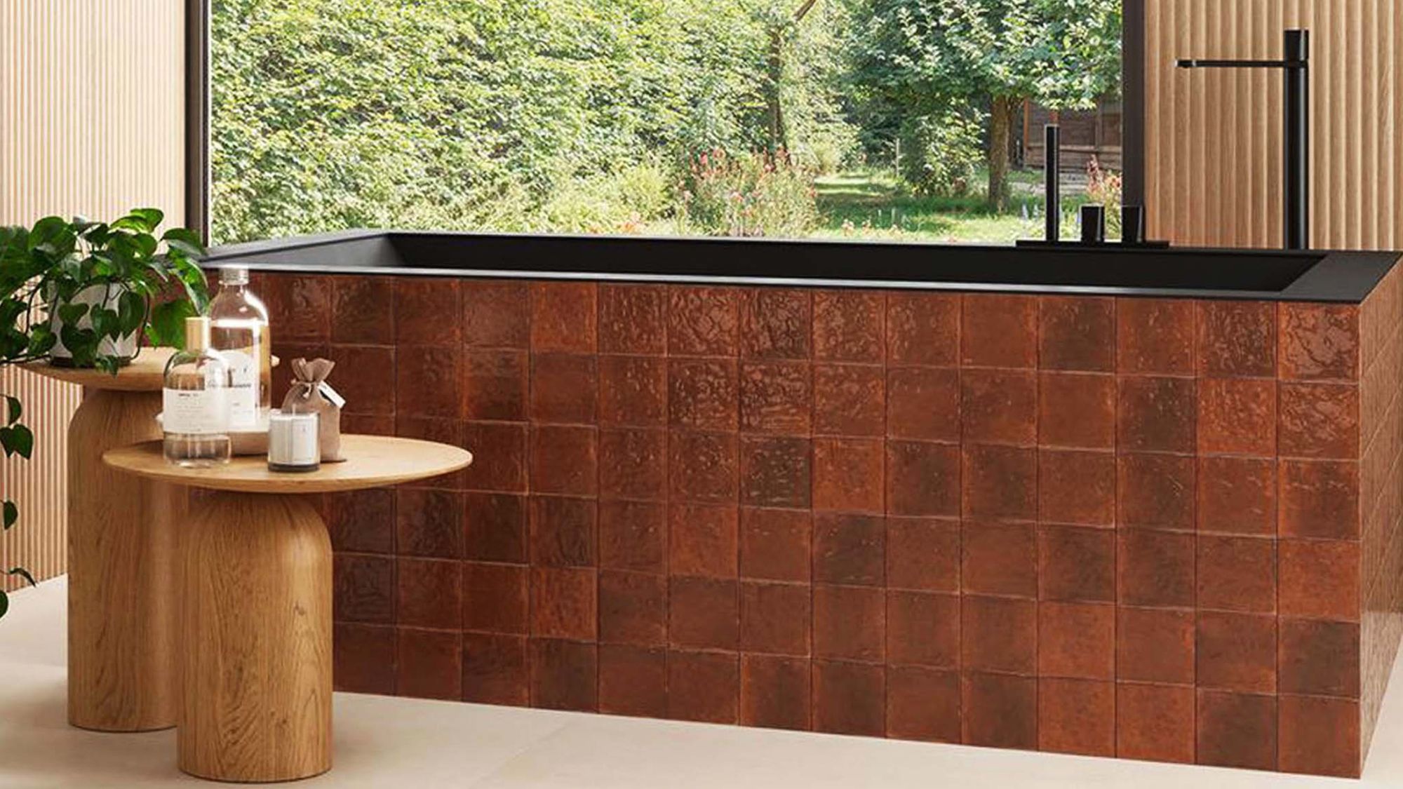 A wide, high-angle shot of a modern, spa-like bathroom featuring a rectangular bathtub clad in glossy, amber-coloured terracotta tiles