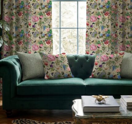 Carrie Neely for Terrys Paradise velvet floral curtains and matching cushions, styled with a teal velvet sofa in a maximalist living room with plants and gold accents. The fabric has Chinoiserie-inspired motifs of vintage florals, and botanicals.
