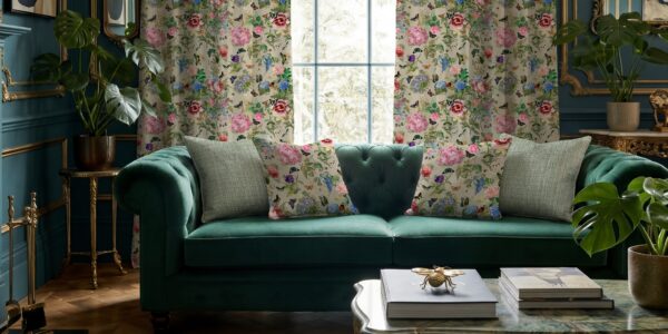 Carrie Neely for Terrys Paradise velvet floral curtains and matching cushions, styled with a teal velvet sofa in a maximalist living room with plants and gold accents. The fabric has Chinoiserie-inspired motifs of vintage florals, and botanicals.