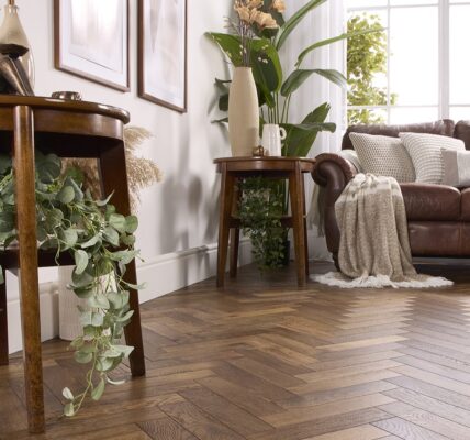 Alston Double Smoked herringbone engineered oak flooring in a brightly lit, modern living room with a brown leather sofa and wooden side tables