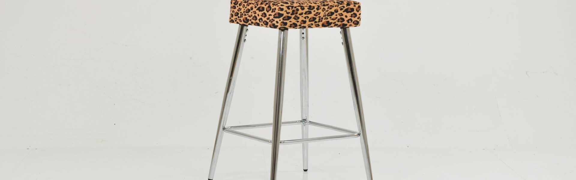 Modern bar stool featuring a square leopard print upholstered seat and polished chrome legs with a footrest.