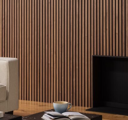 Deep walnut acoustic slatwall panelling mounted on a living room wall behind a sofa and fireplace