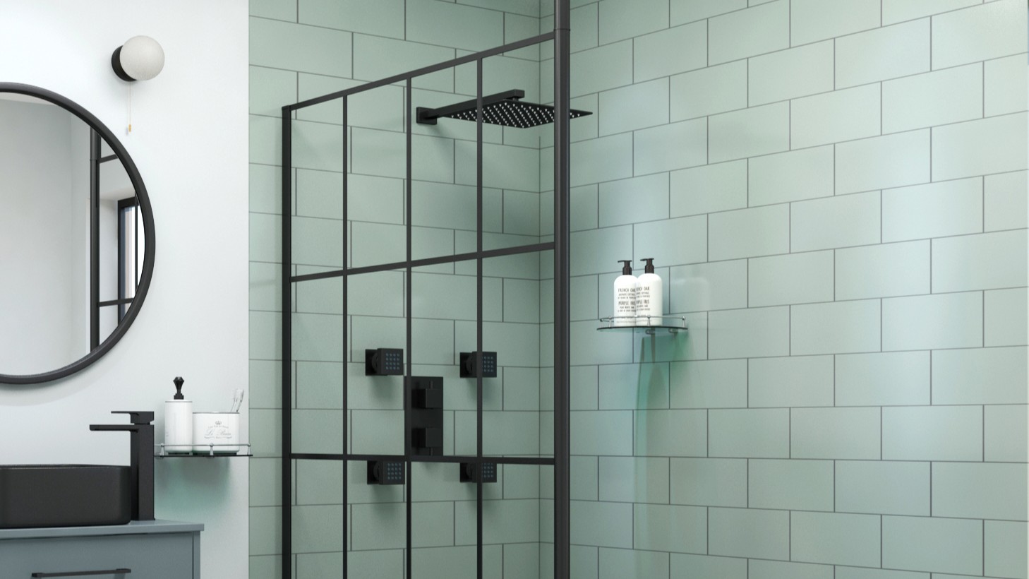 A modern bathroom featuring a black grid wet room shower screen against sage green subway tiles, alongside a black rainfall shower head and matching fixtures.